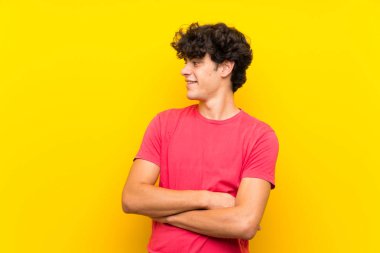 Izole sarı duvar üzerinde yan bakan genç adam