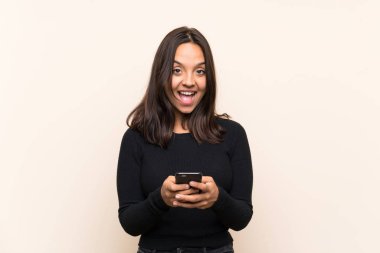 Izole arka plan üzerinde beyaz kazak ile genç esmer kadın şaşırttı ve bir mesaj gönderme