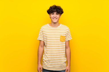 Izole sarı duvar üzerinde genç adam çok gülümsüyor