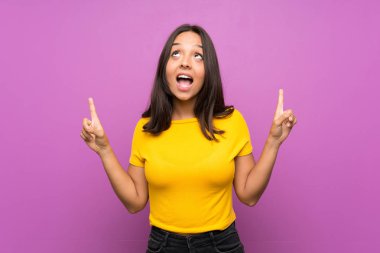 Izole arka plan üzerinde Genç esmer kız şaşırttı ve işaret