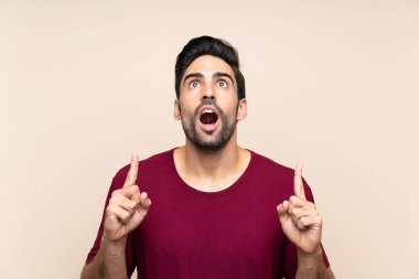 İşaret parmağı ile işaret izole arka plan üzerinde Yakışıklı genç adam harika bir fikir