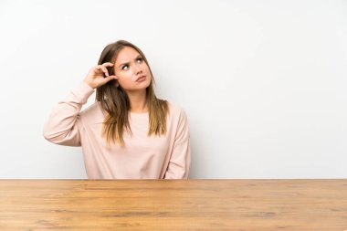 Bir masada genç kız şüpheleri olan ve yüz ifadesi karıştırmayın