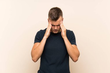 Baş ağrısı ile izole arka plan üzerinde Genç yakışıklı sarışın adam