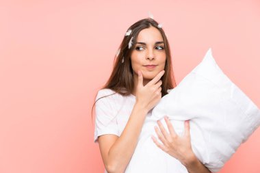 Izole pembe arka plan üzerinde pijama genç kadın bir fikir düşünme