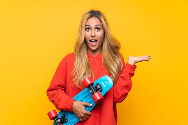 Genç patenci kadın izole sarı arka plan üzerinde sürpriz jest yapıyor