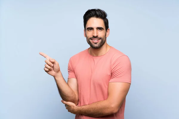 Handsome Young Man Pink Shirt Isolated Blue Background Pointing Finger — Stockfoto