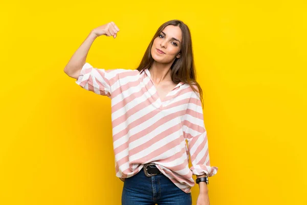 Jovem Mulher Sobre Fundo Amarelo Isolado Fazendo Gesto Forte — Fotografia de Stock