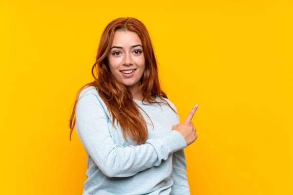 Adolescente Rossa Ragazza Isolato Sfondo Giallo Che Punta Verso Lato — Foto Stock