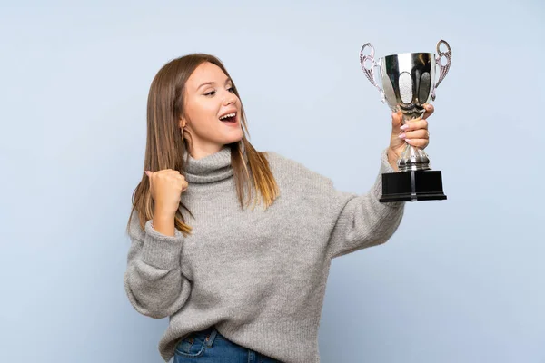 Ragazza Adolescente Con Maglione Sfondo Blu Isolato Possesso Trofeo — Foto Stock