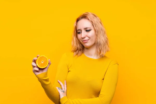 Młoda Kobieta Trzymanie Pomarańczy Białym Tle Żółtym Smutnym Wyrazem — Zdjęcie stockowe