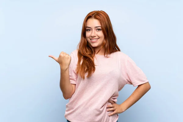 Adolescente Rossa Ragazza Isolato Sfondo Blu Che Punta Verso Lato — Foto Stock