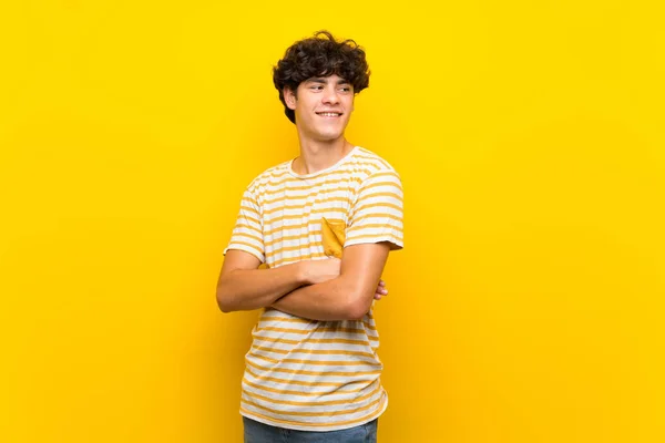 Young Man Isolated Yellow Wall Arms Crossed Happy — Stockfoto