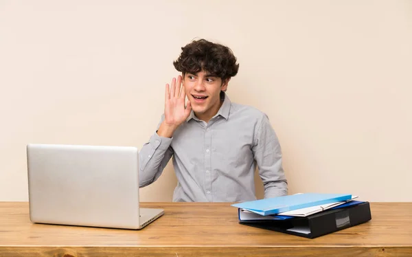 Bir Dizüstü Bilgisayar Ile Genç Öğrenci Adam Kulağına Koyarak Bir — Stok fotoğraf