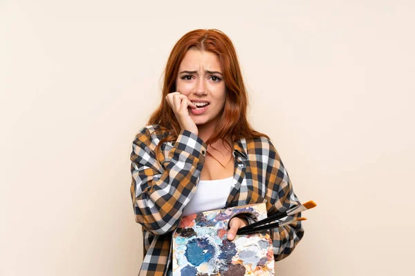 Adolescente Ruiva Menina Segurando Uma Paleta Sobre Fundo Isolado Nervoso — Fotografia de Stock