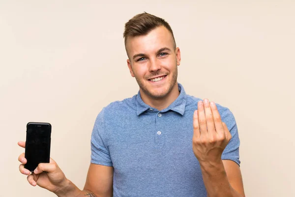 Young Blonde Man Using Mobile Phone Inviting Come Hand Happy — Stock Photo, Image