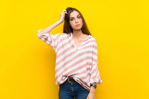 Young woman over isolated yellow background with an expression of frustration and not understanding