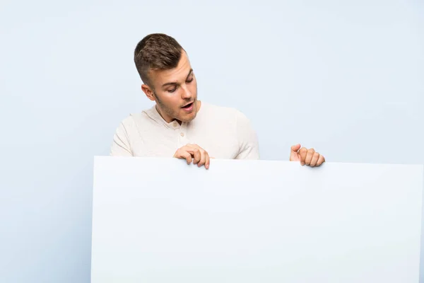 Joven Guapo Hombre Rubio Sobre Fondo Azul Aislado Sosteniendo Cartel —  Fotos de Stock