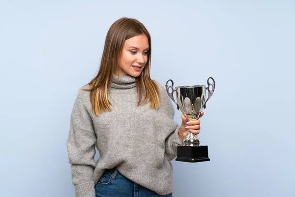 Ragazza Adolescente Con Maglione Sfondo Blu Isolato Possesso Trofeo — Foto Stock