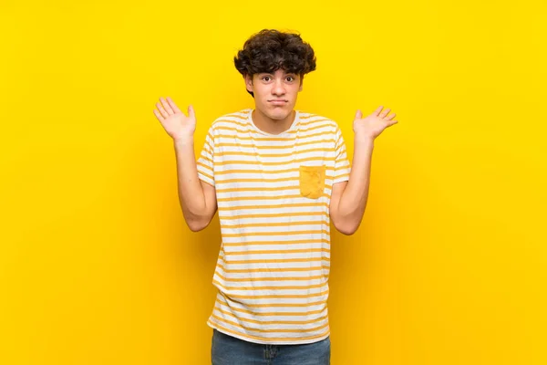Junger Mann Über Abgelegene Gelbe Mauer Macht Geste Der Zweifel — Stockfoto