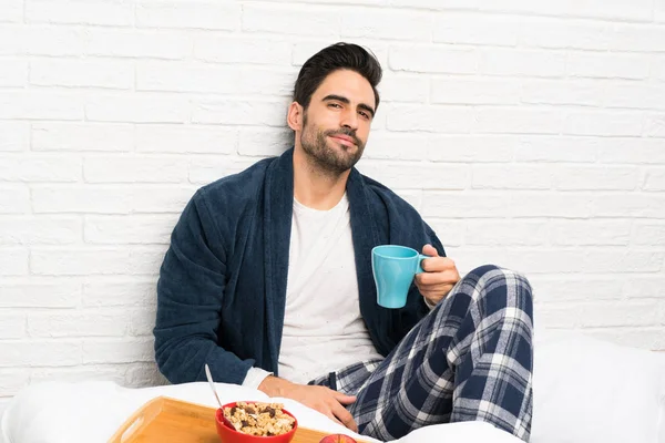 Hombre en la cama con bata y desayunando —  Fotos de Stock