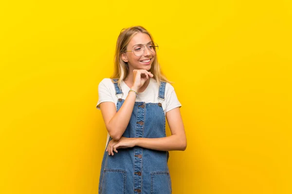 Gözlüklü Izole Sarı Arka Plan Üzerinde Sarışın Genç Kadın — Stok fotoğraf