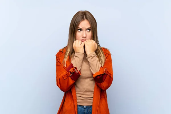 Ragazza Adolescente Con Cappotto Isolato Sfondo Blu Nervoso Spaventato Mettendo — Foto Stock