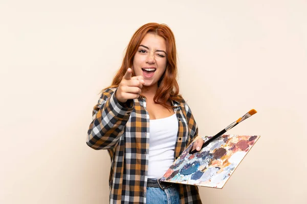 Adolescente Ruiva Menina Segurando Uma Paleta Sobre Fundo Isolado Aponta — Fotografia de Stock