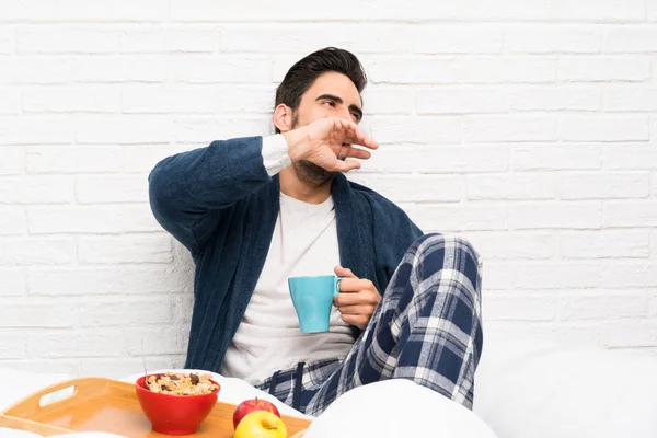 Man in bed with dressing gown and having breakfast