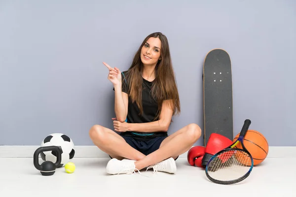 Jovem Mulher Esporte Sentado Chão Apontando Dedo Para Lado — Fotografia de Stock