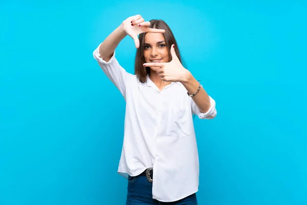 Ung Kvinna Över Isolerad Blå Bakgrund Fokuserings Ansikte Inramnings Symbol — Stockfoto