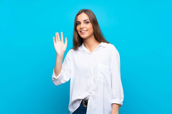 Jonge Vrouw Geïsoleerde Blauwe Achtergrond Salueren Met Hand Met Gelukkige — Stockfoto