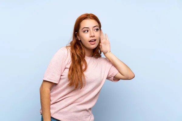 Adolescente Ruiva Menina Sobre Isolado Fundo Azul Ouvir Algo Colocando — Fotografia de Stock