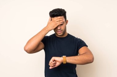 Kol saati ile izole arka plan üzerinde genç yakışıklı adam ve şaşırttı