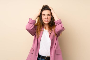 Spor ceketli genç esmer kız izole bir arka planda hayal kırıklığına uğradı ve ellerini kafaya koydu.