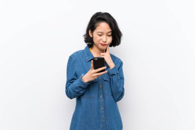 Izole beyaz arka plan düşünme ve bir mesaj gönderme üzerinde Asyalı genç kadın
