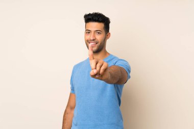 Tecrit edilmiş genç yakışıklı adam parmağını kaldırıyor ve gösteriyor.