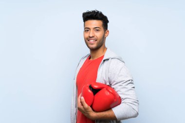 Izole mavi duvar üzerinde boks eldiven ile Spor adam