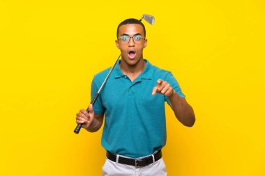 Afrikalı Amerikalı golfçü şaşırdı ve ön tarafı işaret etti.