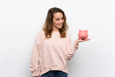 Büyük bir kumbara tutan genç sarışın kadın