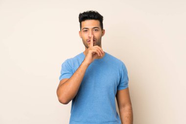 Tecrit edilmiş genç ve yakışıklı bir adam sessizlik işareti gösteriyor. Parmağını ağzına sok.