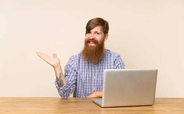 Homem Ruivo Com Longa Barba Uma Mesa Com Laptop Segurando — Fotografia de Stock