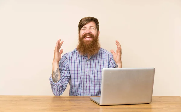 Homem Ruivo Com Barba Comprida Uma Mesa Com Laptop Rindo — Fotografia de Stock