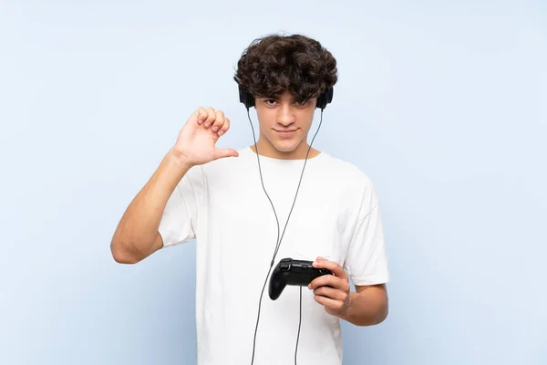 Νέος Άνθρωπος Παίζει Ένα Χειριστήριο Βιντεοπαιχνιδιών Πάνω Από Απομονωμένο Μπλε — Φωτογραφία Αρχείου