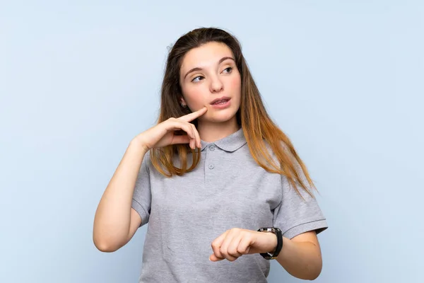 Giovane Ragazza Bruna Sfondo Blu Isolato Con Orologio Polso Pensando — Foto Stock