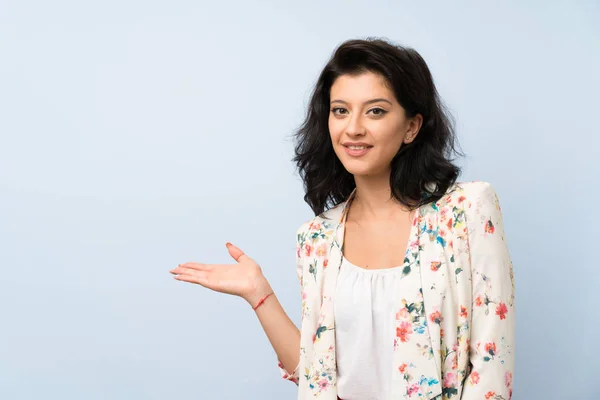 Jovem Mulher Sobre Fundo Azul Isolado Segurando Copyspace Imaginário Palma — Fotografia de Stock