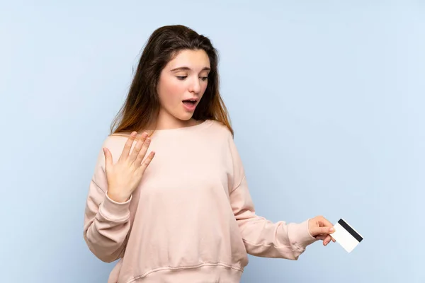 Joven Morena Sobre Fondo Azul Aislado Sosteniendo Una Tarjeta Crédito — Foto de Stock