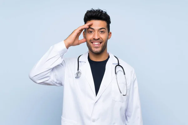 Joven Médico Sobre Aislada Pared Azul Con Sorpresa Expresión Facial —  Fotos de Stock