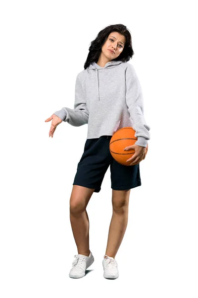 一个年轻女子打篮球的全景镜头 她一边举着肩膀 一边在孤零零的白色背景上做着怀疑的手势 — 图库照片