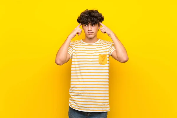 Junger Mann Über Isolierter Gelber Wand Mit Zweifeln Und Denken — Stockfoto
