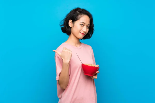 Ασιατικές Νεαρή Γυναίκα Κρατώντας Ένα Μπολ Δημητριακών Που Δείχνουν Στο — Φωτογραφία Αρχείου